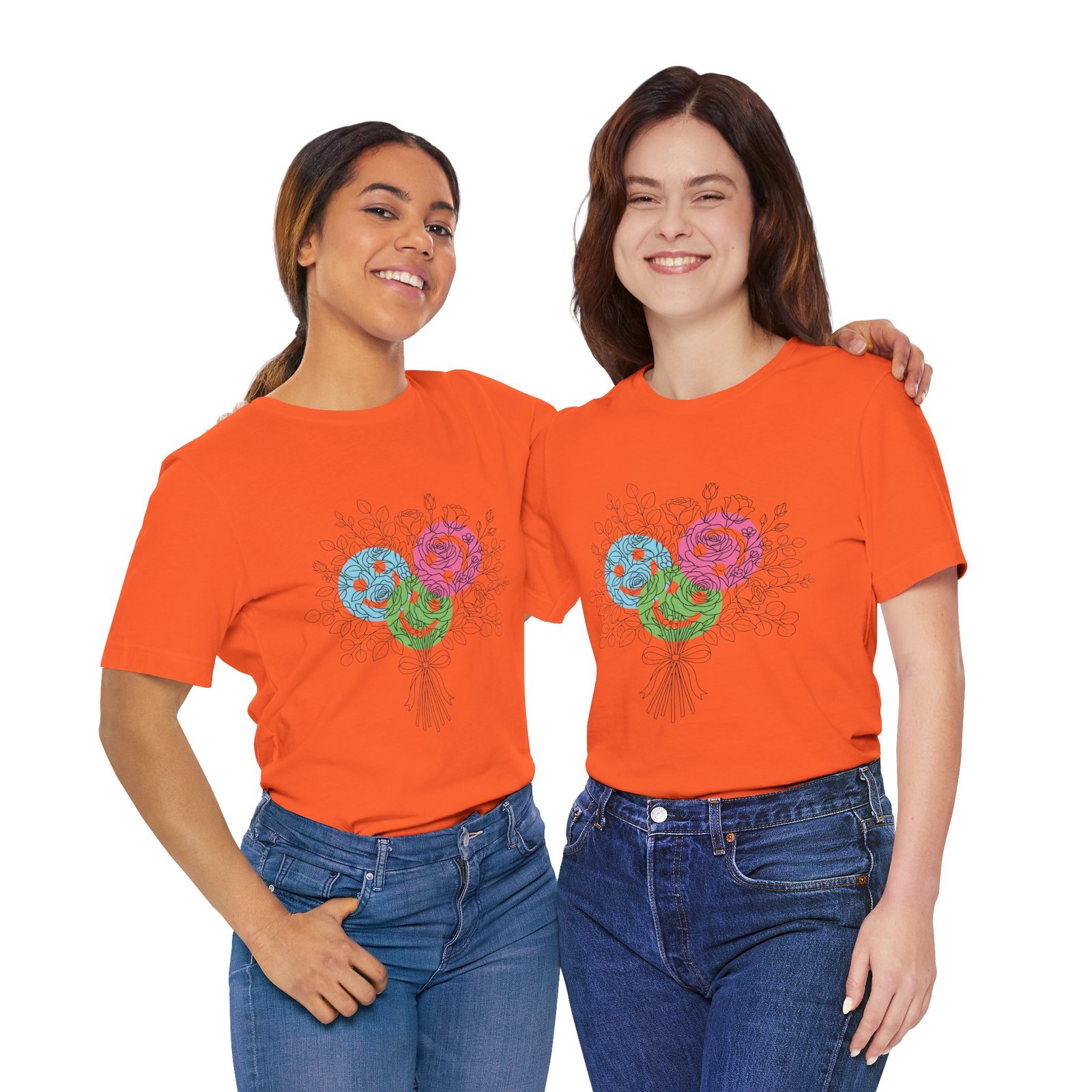 Two women wearing orange T-shirts featuring a colorful floral yarn bouquet print with teal, magenta, and lime blooms.