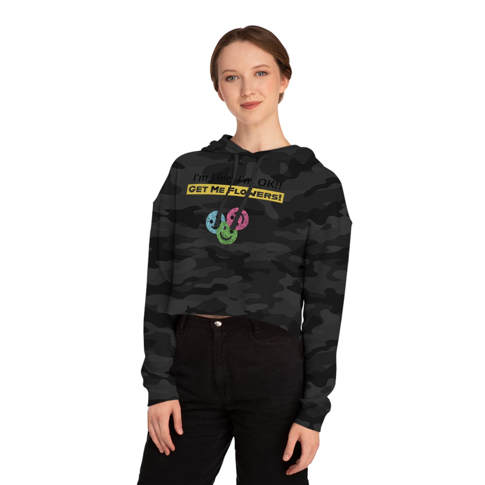 Woman wearing a black camouflage cropped hoodie with yellow text saying "I'm Fine! I'm OK!! GET ME FLOWERS!" and floral icons.