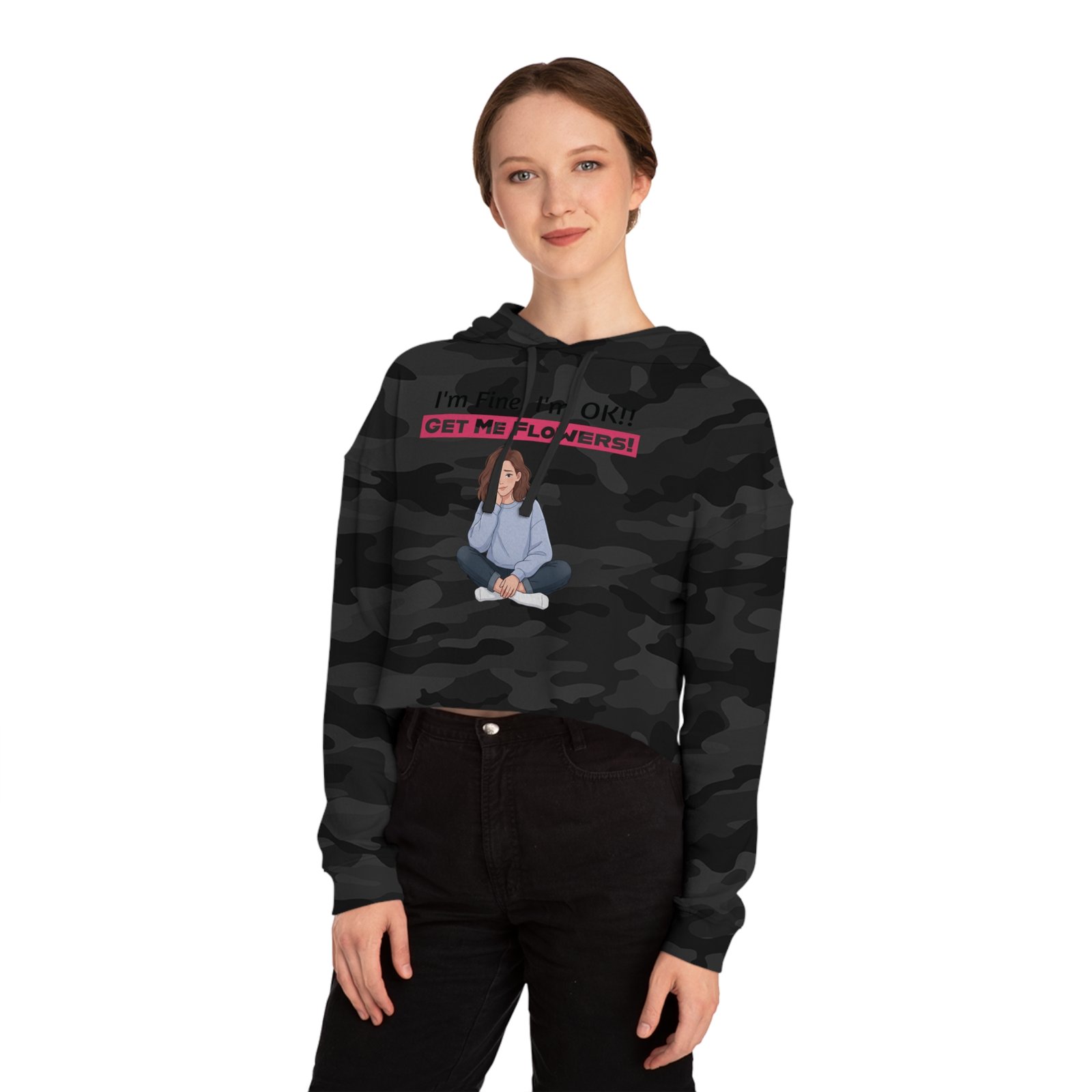 Woman wearing a camouflage cropped hoodie with a graphic of a girl and pink text "I'm Fine! I'm OK!! GET ME FLOWERS!"