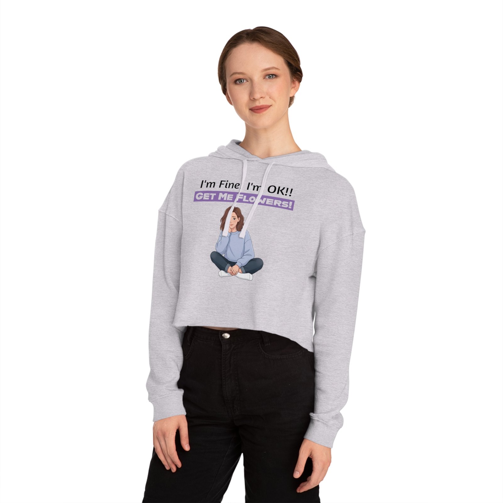 Woman wearing a grey cropped hoodie featuring a graphic of a seated girl and text "I'm Fine! I'm OK!! Get Me Flowers!"