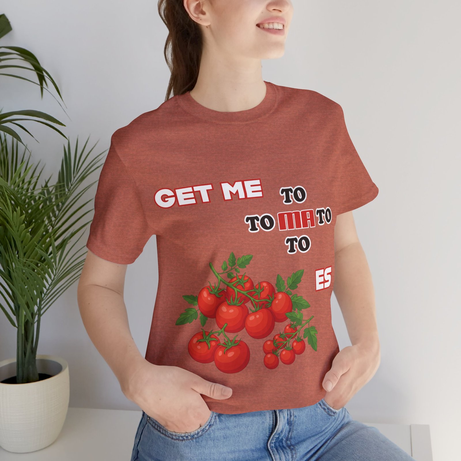 Woman wearing a terracotta Get Me To Ma To Toes T-Shirt featuring vintage tomato illustrations and retro typography.
